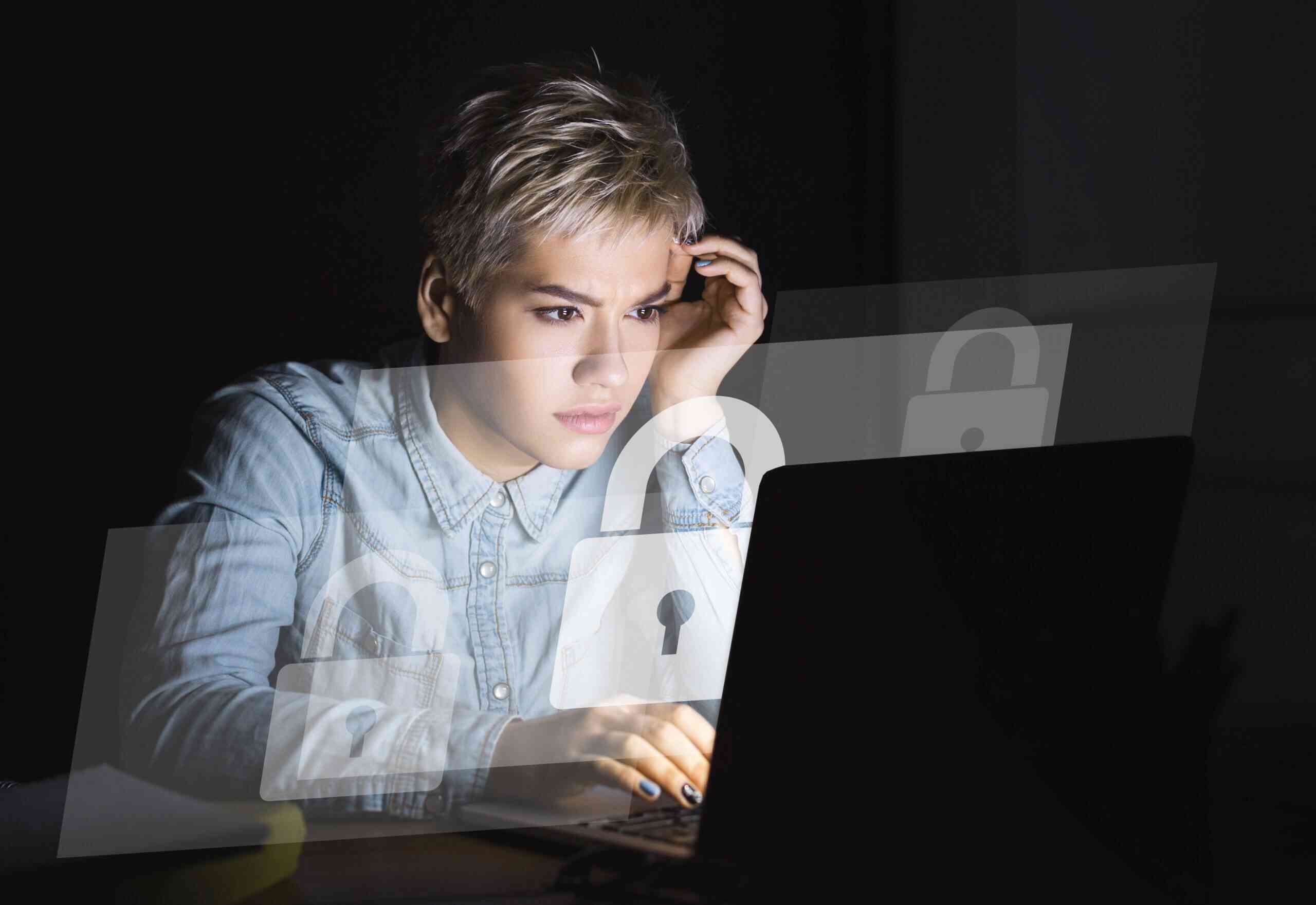 A woman gazes at a laptop screen displaying a padlock, symbolizing security and privacy in digital spaces.