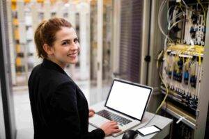 Portrait of technician using laptop while analyzing server in server room