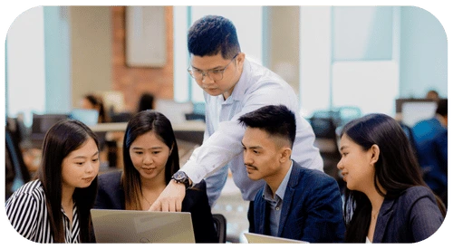 TRT Employees engaged in teamwork around a laptop, dedicated to improving service quality and customized service level agreements.